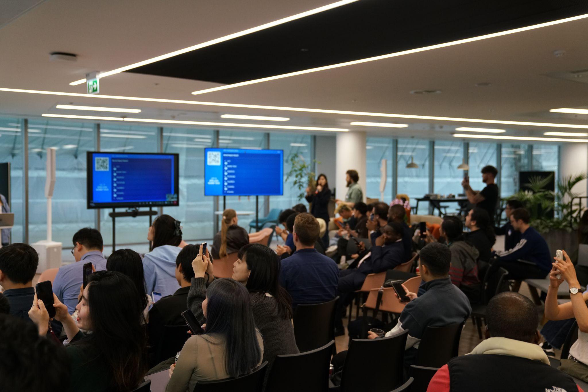 The room during the Build Lab presentations, with the live Slido leaderboard on screen