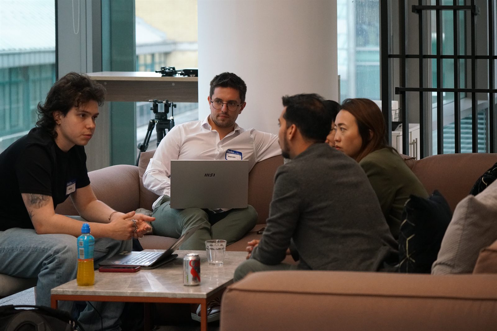 A team collaborating on sofas with laptops during the build