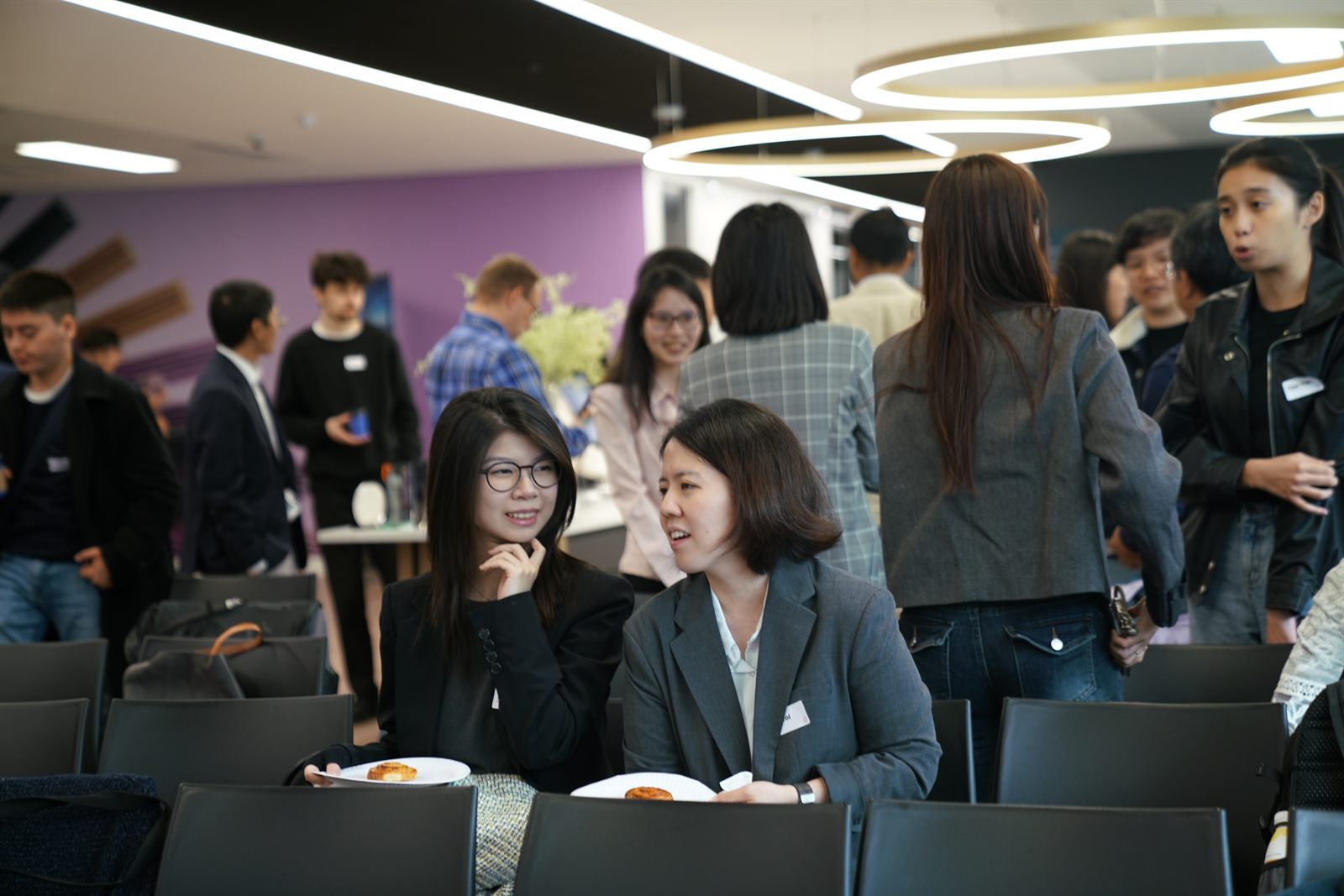 Two attendees chatting over refreshments during the break