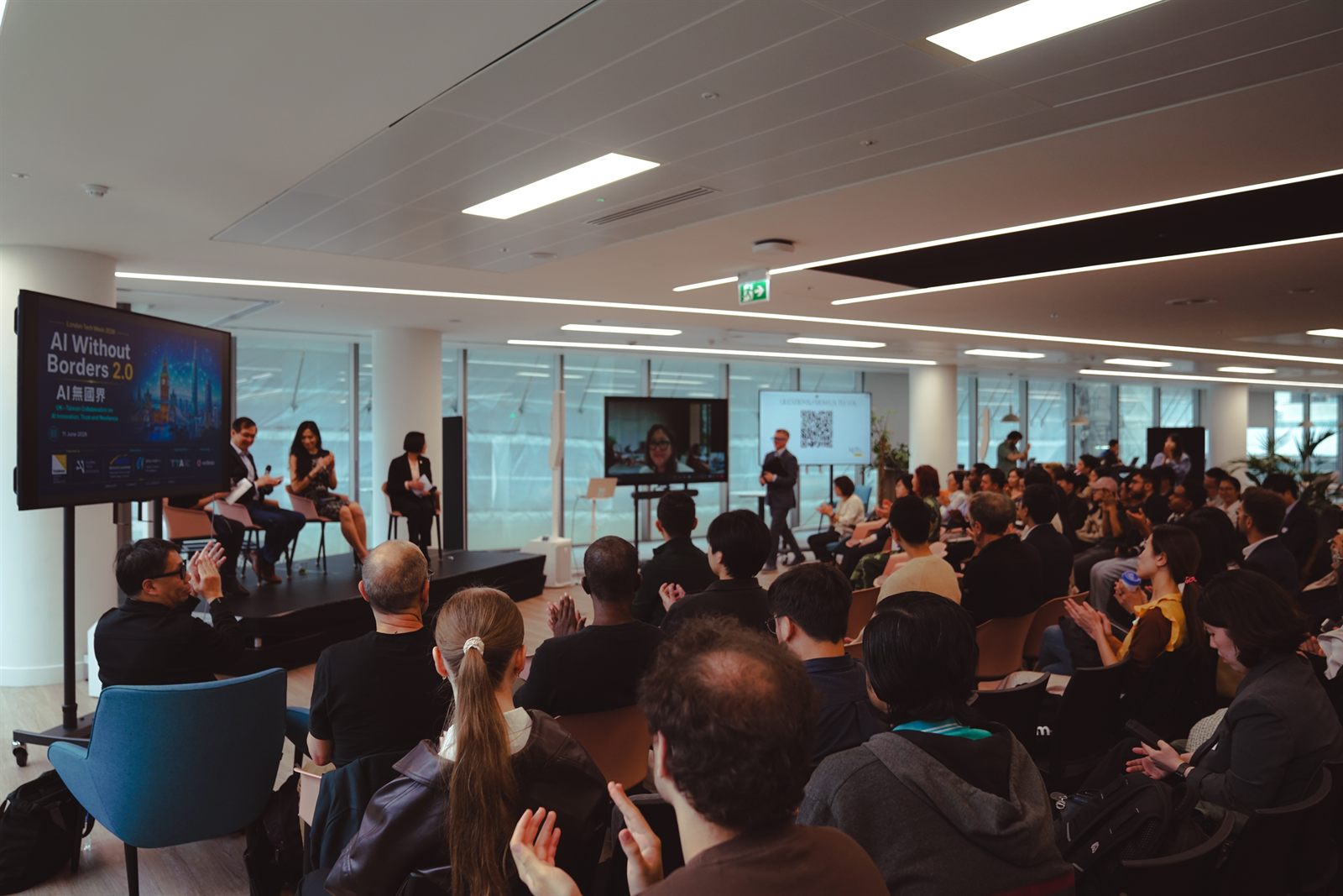 Wide view of the full room during Panel 2, with the panel on stage