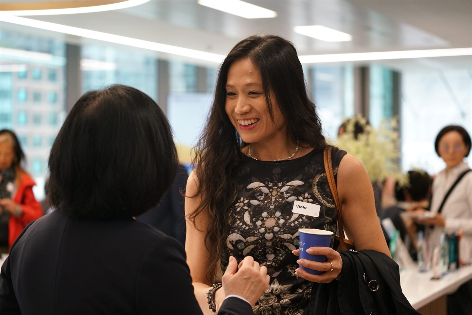 Two attendees in conversation over coffee during morning networking