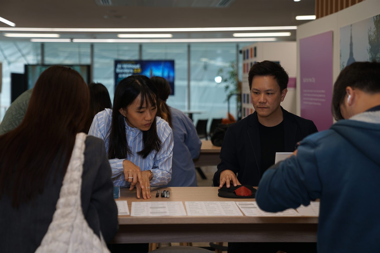 Attendees at the registration tables in front of the AI Without Borders 2.0 screen