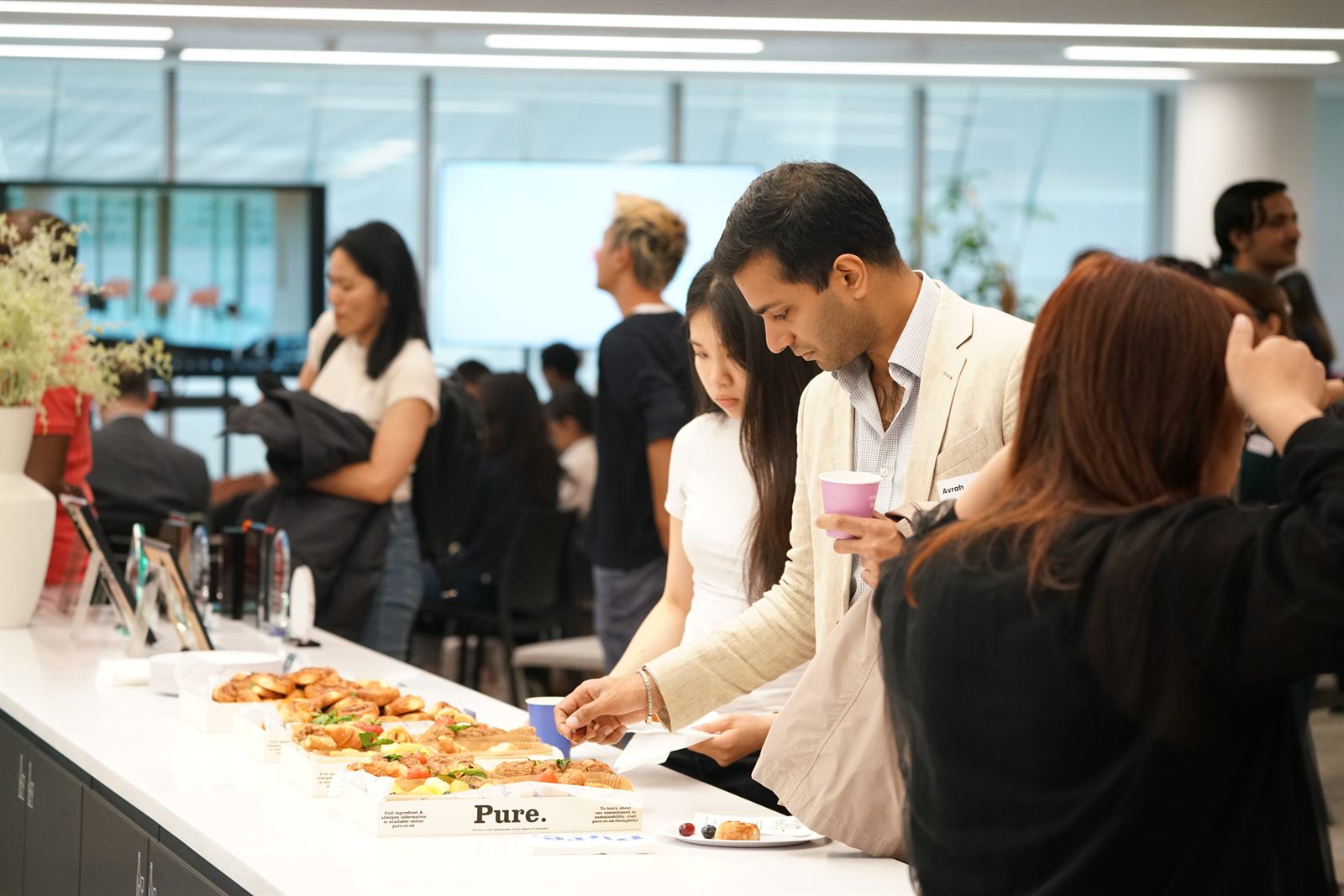 Guests gathering around the refreshments table before the programme